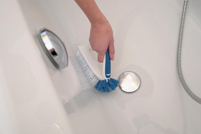 Reinigung der Badewanne mit robuster Flachbürste von Unger mit blauem Griff