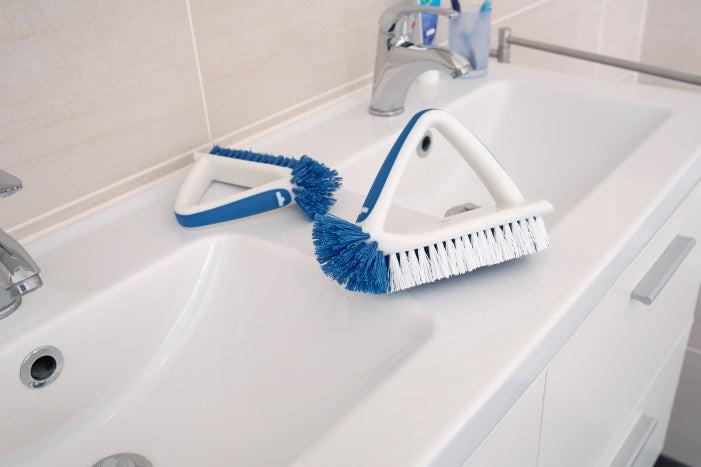 Unger Eckreinigungsbürste und Flachbürste auf Waschbecken – perfekte Kombi für hygienische Sauberkeit im Bad