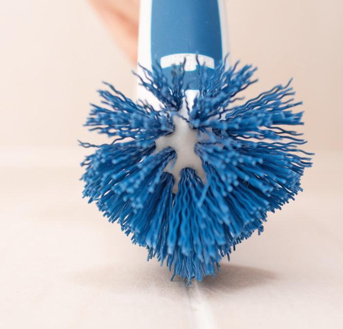 Nahaufnahme einer Hand mit der Unger Eckreinigungsbürste beim Reinigen von Fugen