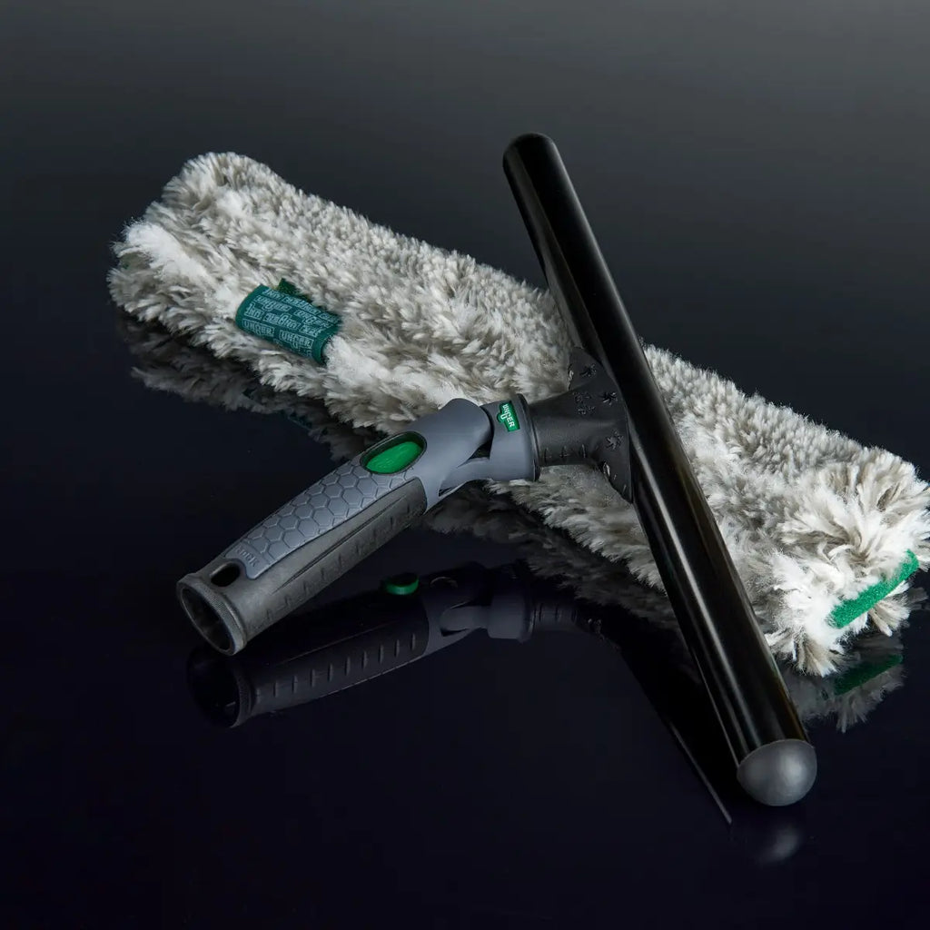 Unger ErgoTec Ninja Fensterreiniger mit Mikrofaser-Einwascher und Stange auf spiegelndem schwarzem Hintergrund