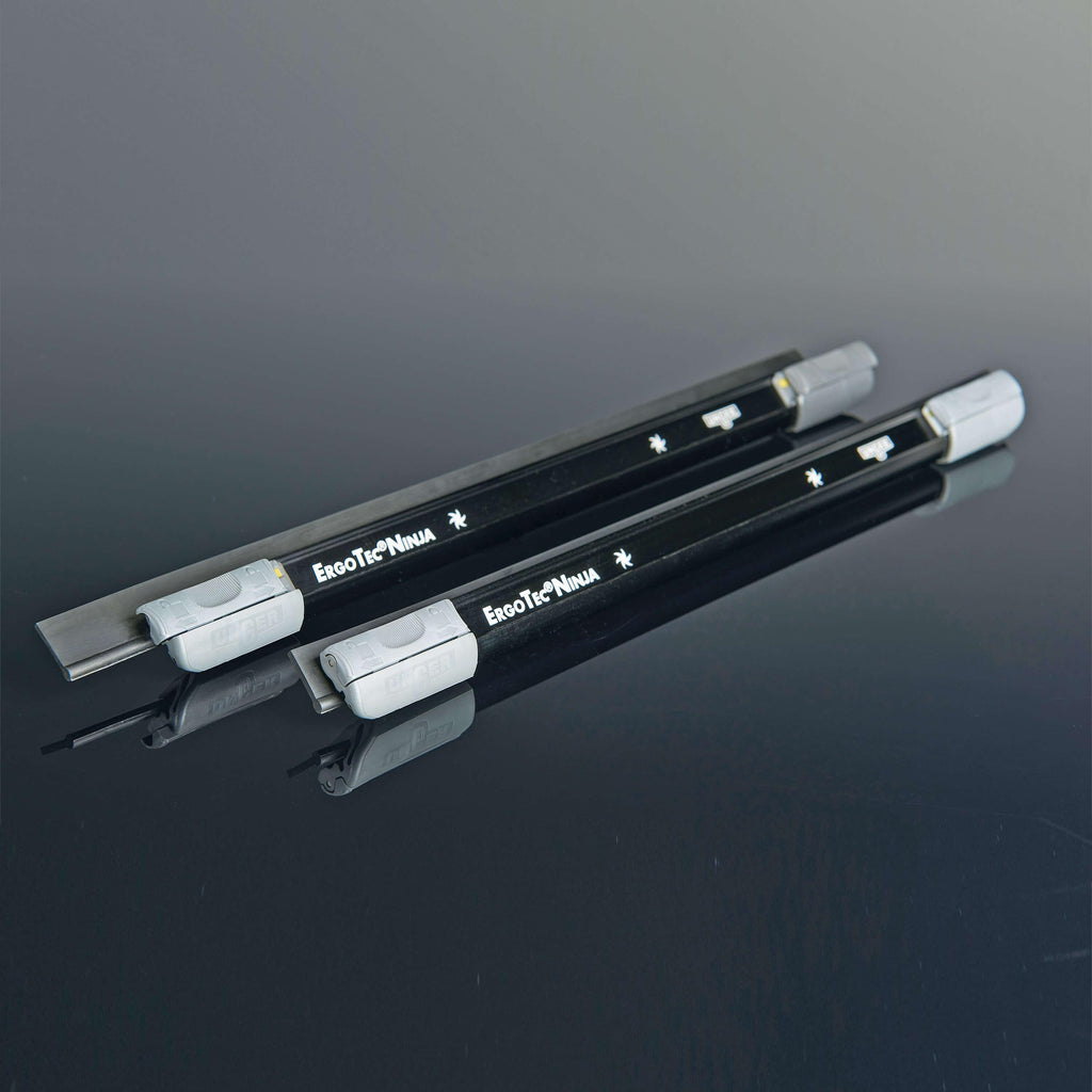 Zwei schwarze Schienen des Unger ErgoTec Ninja Fensterwischers mit grauen Endkappen, liegend auf schwarzem Hintergrund – Zubehör des 6in1 Complete Kits AKN14