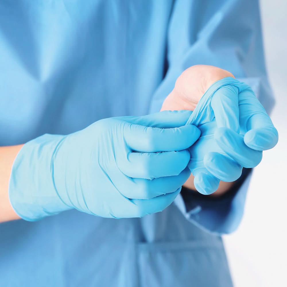 Person zieht Hygonorm "Safe Fit" Nitril-Handschuhe Blau 200 Stück von Franz Mensch als Hygieneartikel an.