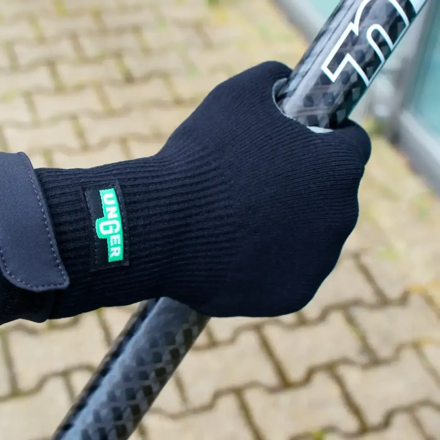 Schwarzer schwarzer gestrickter unger ergo tec glasreinigungshandschuh mit grünem unger logo auf der rückseite