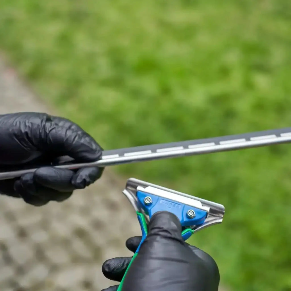 Unger green label s-schiene mit gummi blau grün griffe metallic klinge gehalten von handschuhen