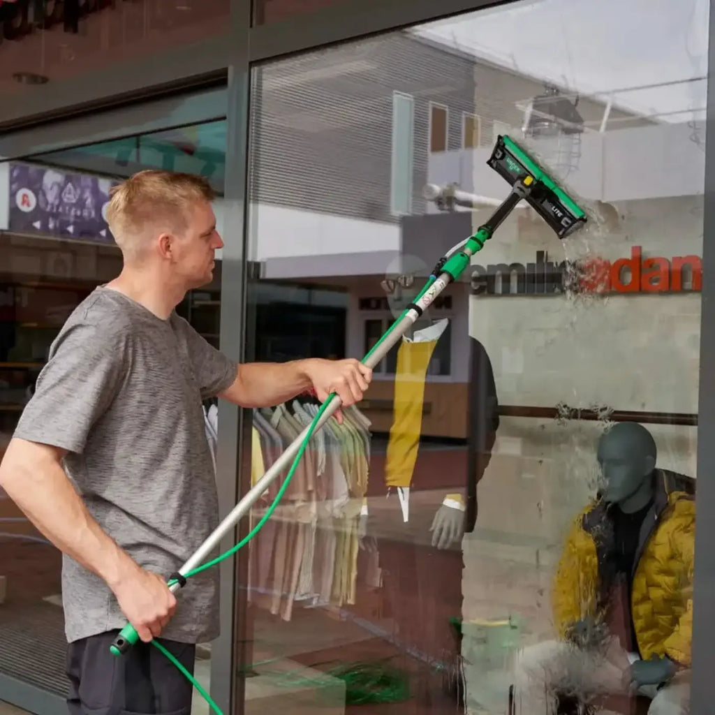 Grüner und schwarzer teleskop-fensterreinigungsstab mit squeegee-kopf und microfiber-reinigungspad von unger nLite