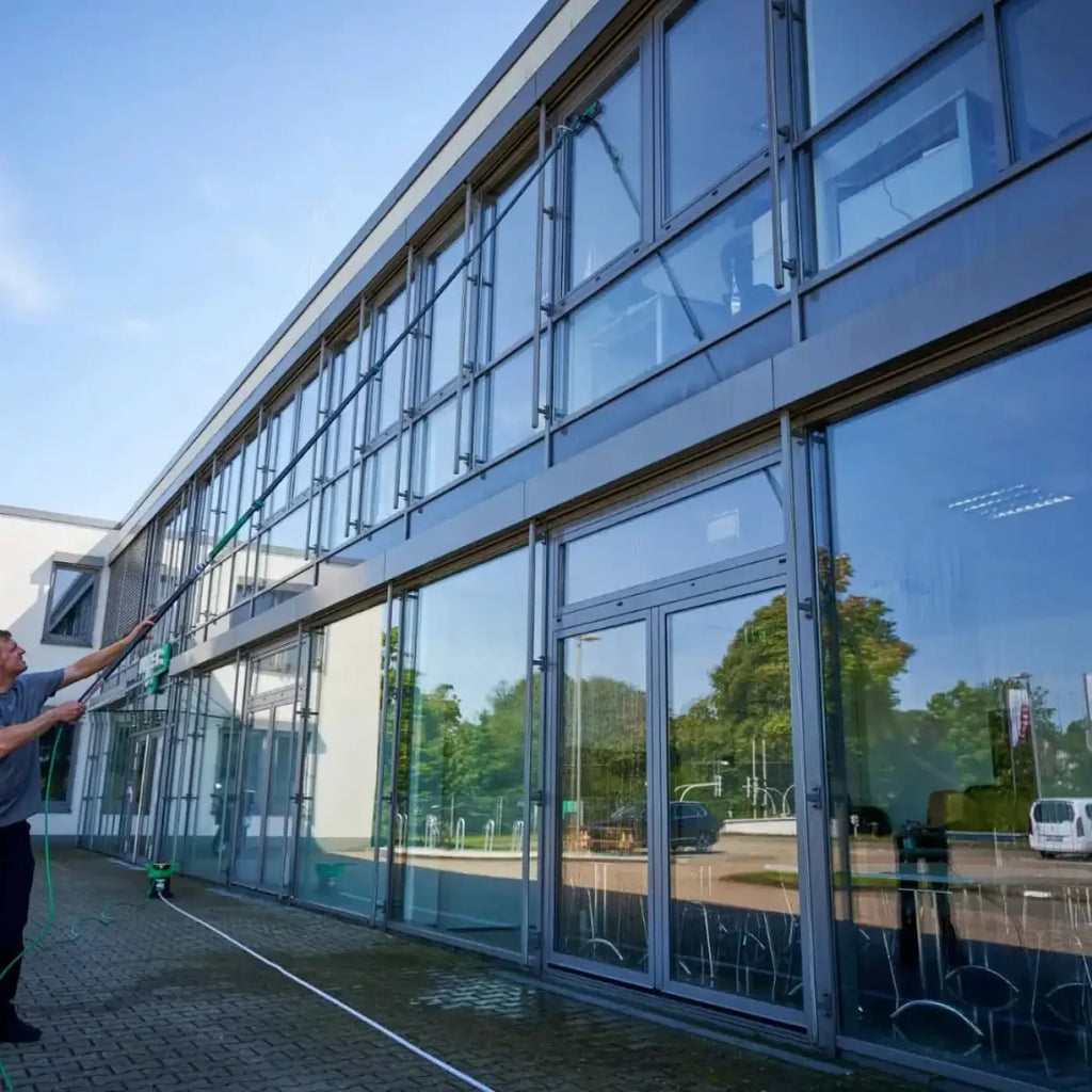 Ein mann reinigt mit einer langen grünen ungert nLite powerpad griff und microfiber-reinigungspad fenster
