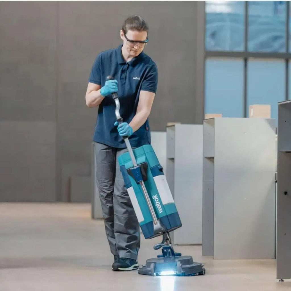 Teal und weiße makita bodenpoliermaschine mit hellem licht am boden im produkt wetrok spin befree